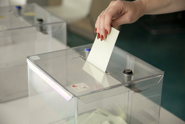 Elections Main qui dépose une enveloppe dans une urne